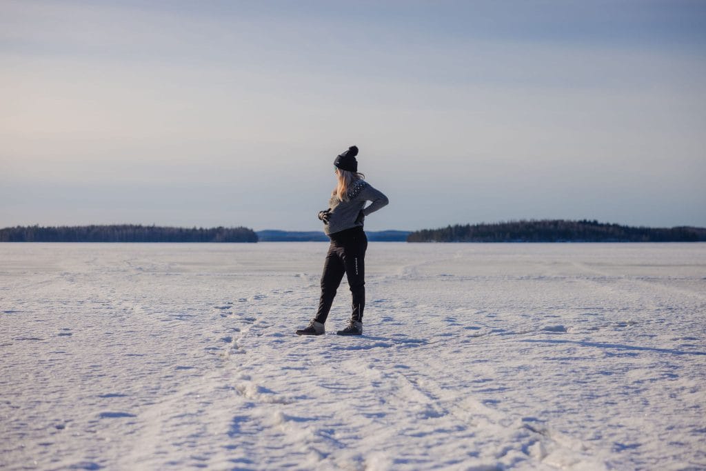 Raskaana oleva nainen järven jäällä.