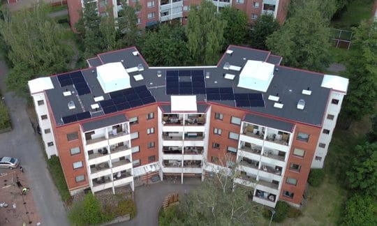 Ilmakuva pilottikohteena toimivasta vuokrakerrostalosta. Aurinkopaneelit peittävät suuren osan käytettävissä olevasta kattopinta-alasta.